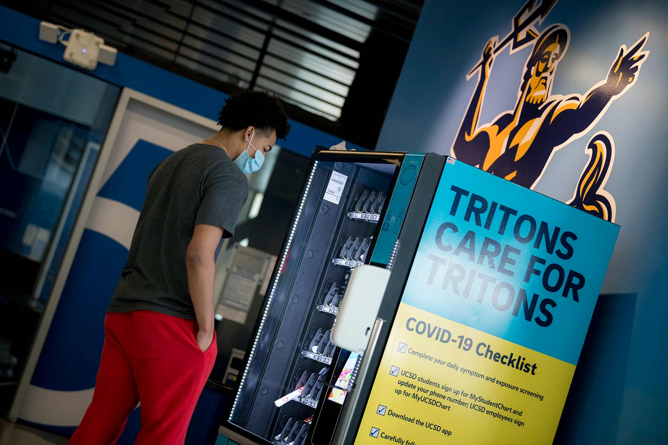 4 of 4, A student using a COVID-19 Test Kit Vending Machine
