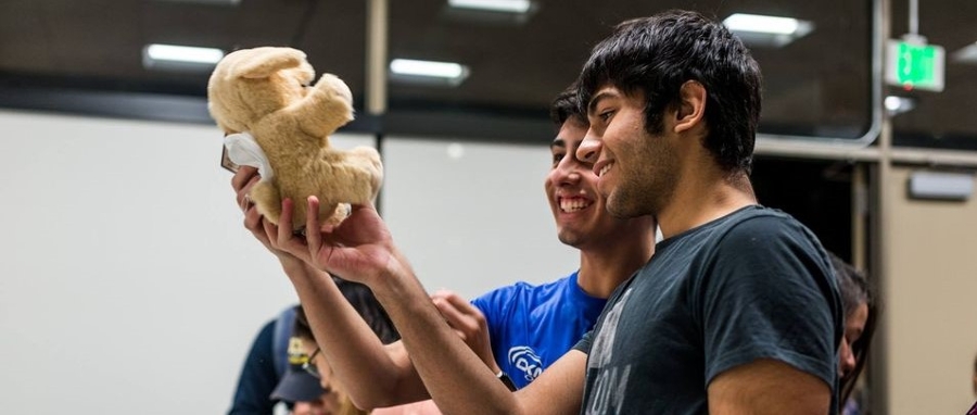 two students holding a bear and stuffing it